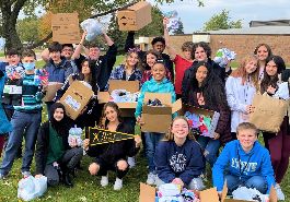  image of Davis junior high students holding boxes and bags of sock donations outside